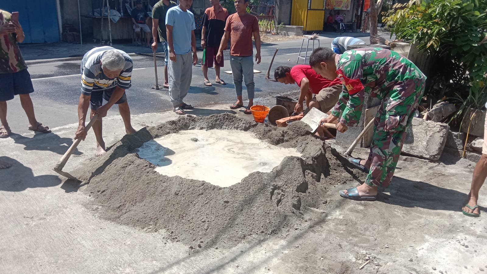 Koptu Suyono, Babinsa Desa Sidowarno Karya Bakti Pengecoran Halaman Gardu Pos Kamling
