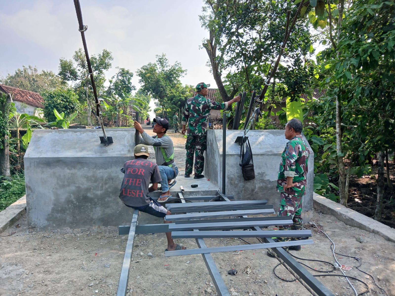 Sinergi TNI dan Warga Warnai Pemasangan Railing Jembatan Gantung Garuda Karangpakel